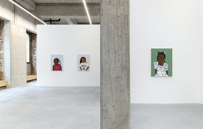 installation view of two white walls, both displaying portrait paintings by Shaina McCoy