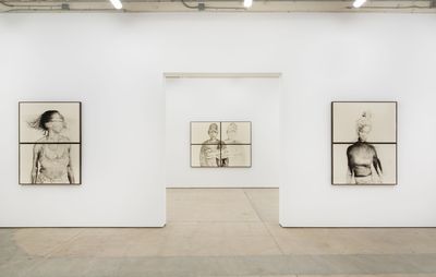 Installation view of white walls with two artworks flanking a doorway and one visible through the doorway