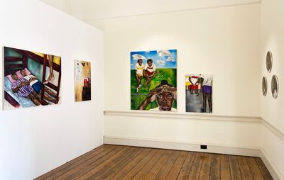 installation view of three white walls with a variety of paintings in differing shapes hung on them