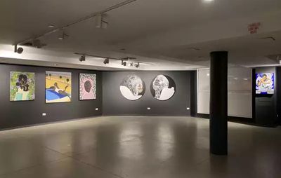 installation view of gallery with black walls and five paintings with black column in centre of room