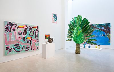 installation view of palm tree sculpture and paintings in a white gallery space