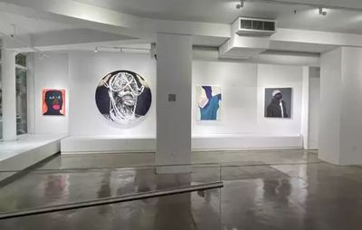 installation view of four paintings by different artists against white walls