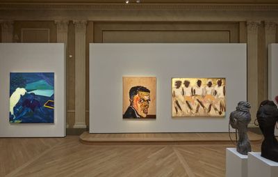 installation view of a large exhibition space displaying a variety of paintings and sculptures on plinths by different artists
