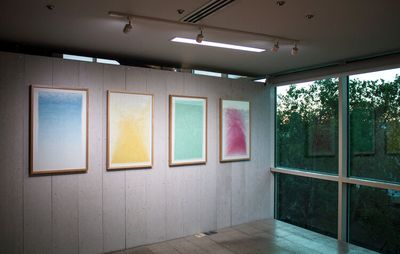 Four artworks displayed in a row on a wall