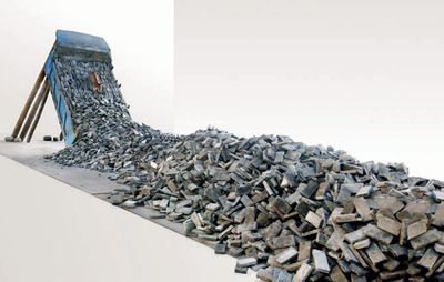 installation view of masses of rubble and objects piled up spilling down