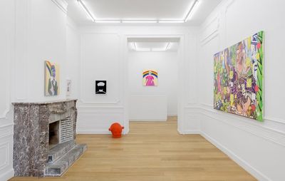 White gallery room, with a marble fireplace to the left. A small red sculpture sitting on the floor by the doorway
