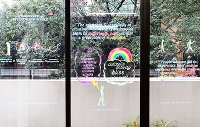 a large glass window split into three separate panes with text and images drawn and painted onto each