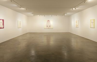 Installation view of a large exhibition space with five paintings spread across three walls