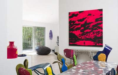 installation view of a large pink and black painting on a wall above a mantlepiece