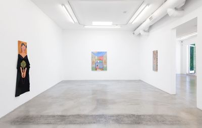 installation view of a large white room with three canvases spread out on different walls
