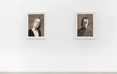 installation view of two portraits on a white wall