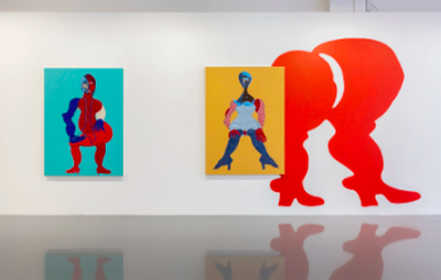 installation view of two colourful abstract portraits hung next to an orange wall painting