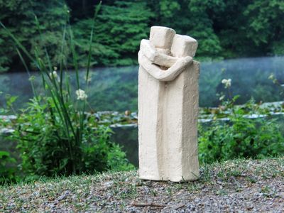 Skulptur in der Natur zweier Personen die sich umarmen