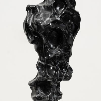 black marble sculpture resembling a face on a bronze pole by Kevin Francis Gray - side close up view