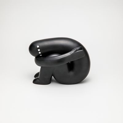 Sculpture of a black figure curled up sitting