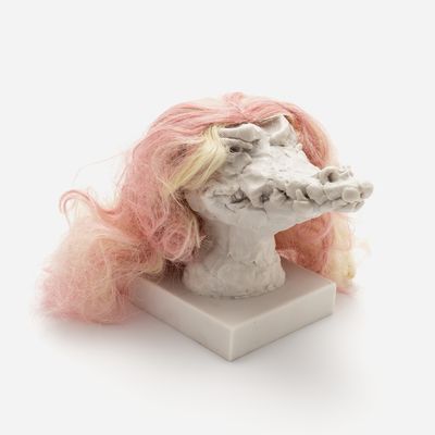 a sculpture of a crocodile head with a custom hair piece in peach pink and yellow, Nathalie Djurberg & Hans Berg