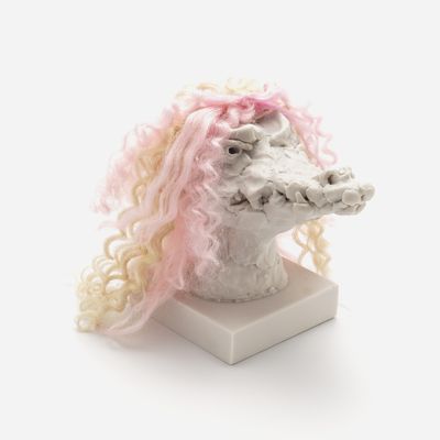 a sculpture of a crocodile head with a custom hair piece in light pink and yellow, Nathalie Djurberg & Hans Berg