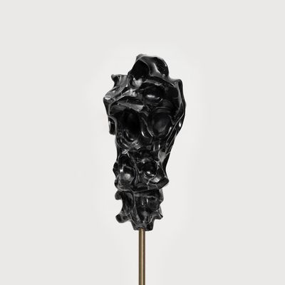 black marble sculpture resembling a face on a bronze pole by Kevin Francis Gray - front close up