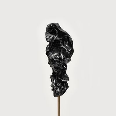 black marble sculpture resembling a face on a bronze pole by Kevin Francis Gray - close up front