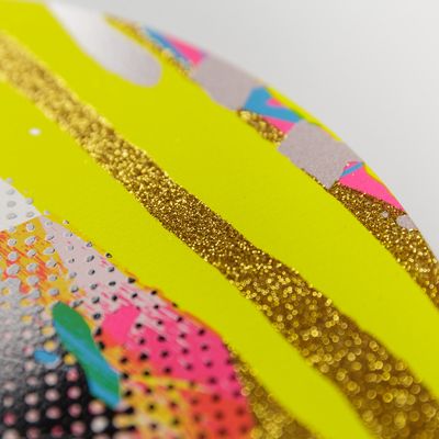 Detail of corner of a print with gold glitter and two yellow stripes over it