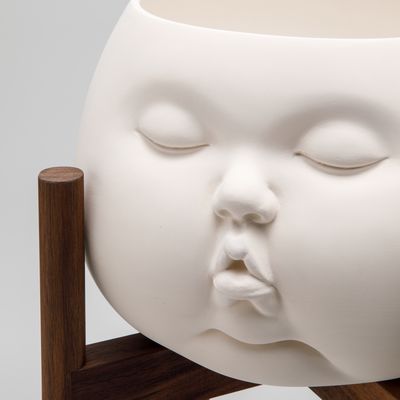 up close of ceramic pot shaped in form of baby face