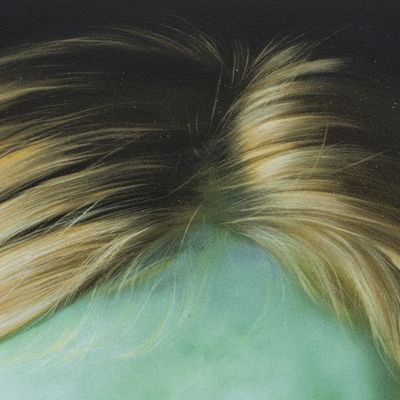 close up of a print with a dappled texture, showing blonde hair and a blue-green face