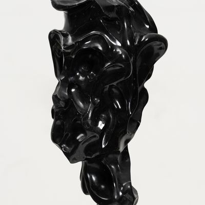 black marble sculpture resembling a face on a bronze pole by Kevin Francis Gray - close up