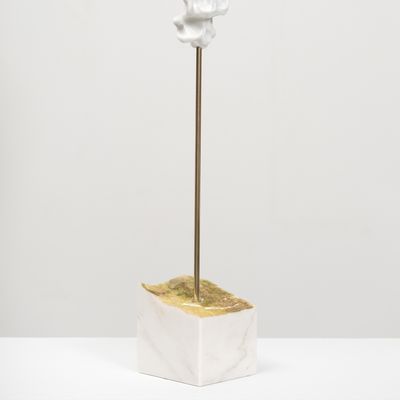 white marble sculpture resembling a face on a bronze pole by Kevin Francis Gray - side view