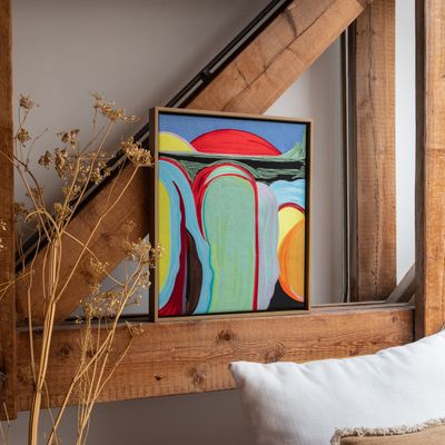 framed tapestry balanced on a wooden beam