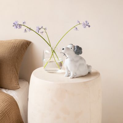 dog sculpture next to a vase of flowers