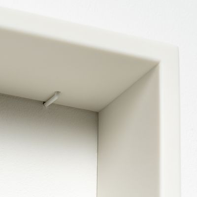 Corner of white resin frame, with small white hanging detail visible close to the corner