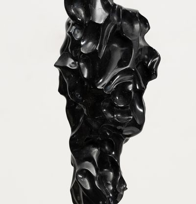 black marble sculpture in an organic shape on a bronze pole by Kevin Francis Gray - close up