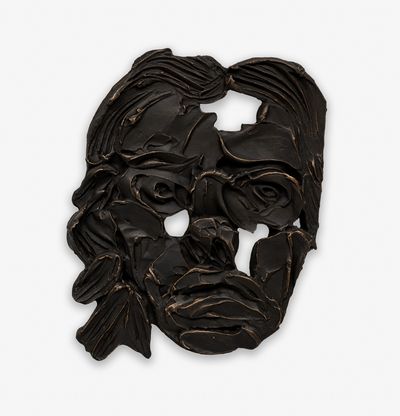 a sculptural mask of a woman finished in black patina