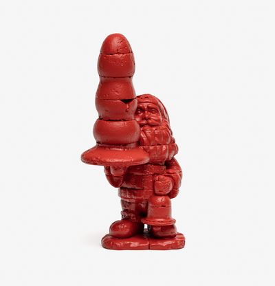 a bronze santa holding a christmas tree shaped butt plug painted in red
