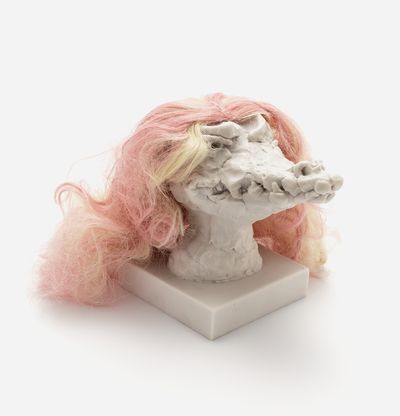 a sculpture of a crocodile head with a custom hair piece in peach pink and yellow, Nathalie Djurberg & Hans Berg