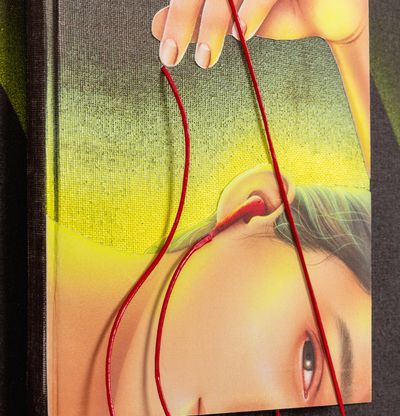 detail of red 3D headphones above book 
