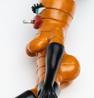 close-up detail of reclining carrot sculpture with a cigarette