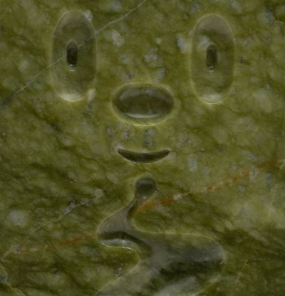 a close-up of a green marble sculpture rendition of Haroshi's endearing character