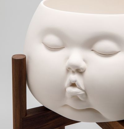 up close of ceramic pot shaped in form of baby face