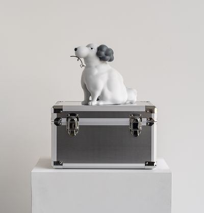 sculpture of a dog on a box on a plinth
