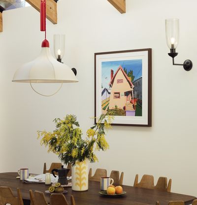 Framed print on the wall of a brightly-lit kitchen, with an enticing spread on the dining table