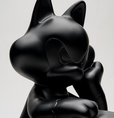Bronze sculpture of a cat rendered in black,  up close of head