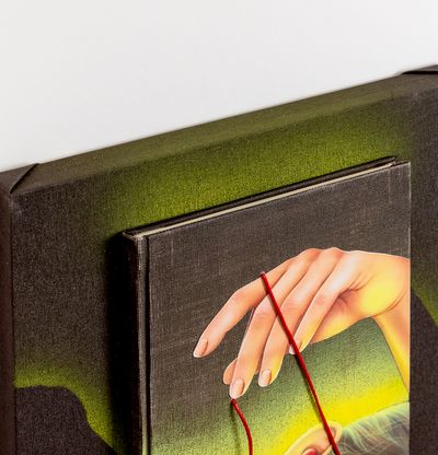 detail of 3D book and canvas with focus on hand of woman