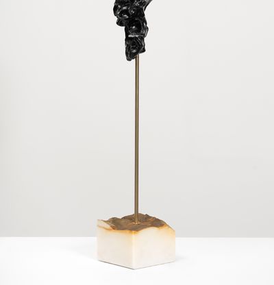 white marble sculpture resembling a face on a bronze pole by Kevin Francis Gray - back view