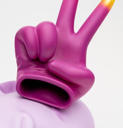 resting pink head with gold tipped peace sign glove resting above