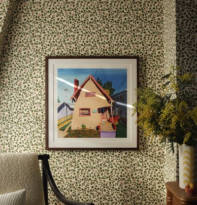 framed print on a sun flecked wall with leafy patterned paper