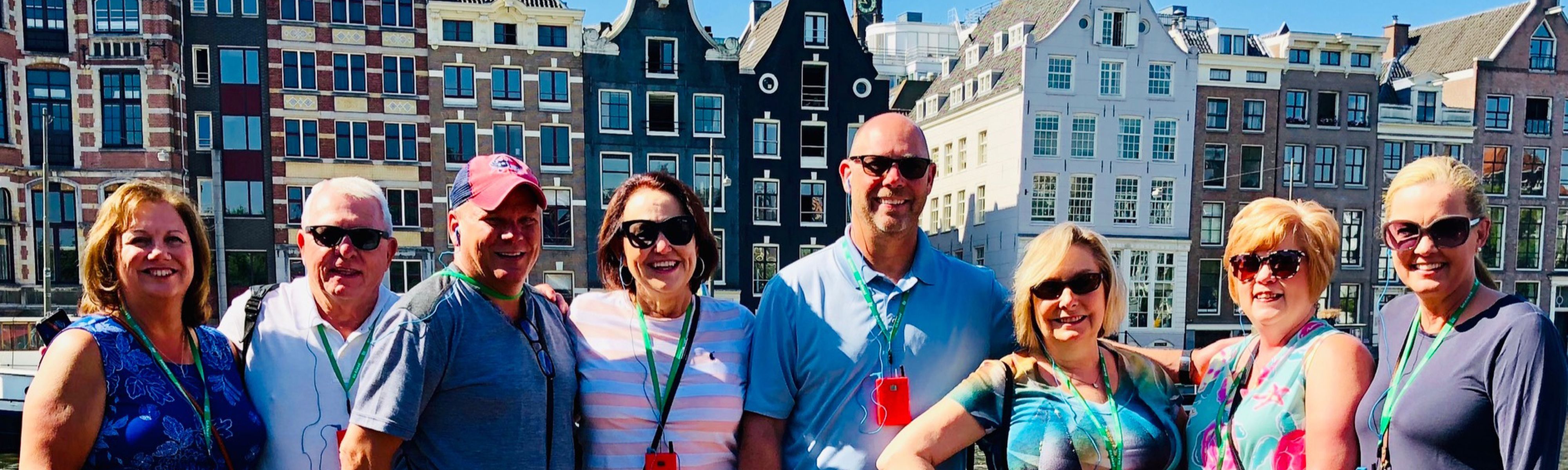 group of travelers in front of colorful homes in amsterdam