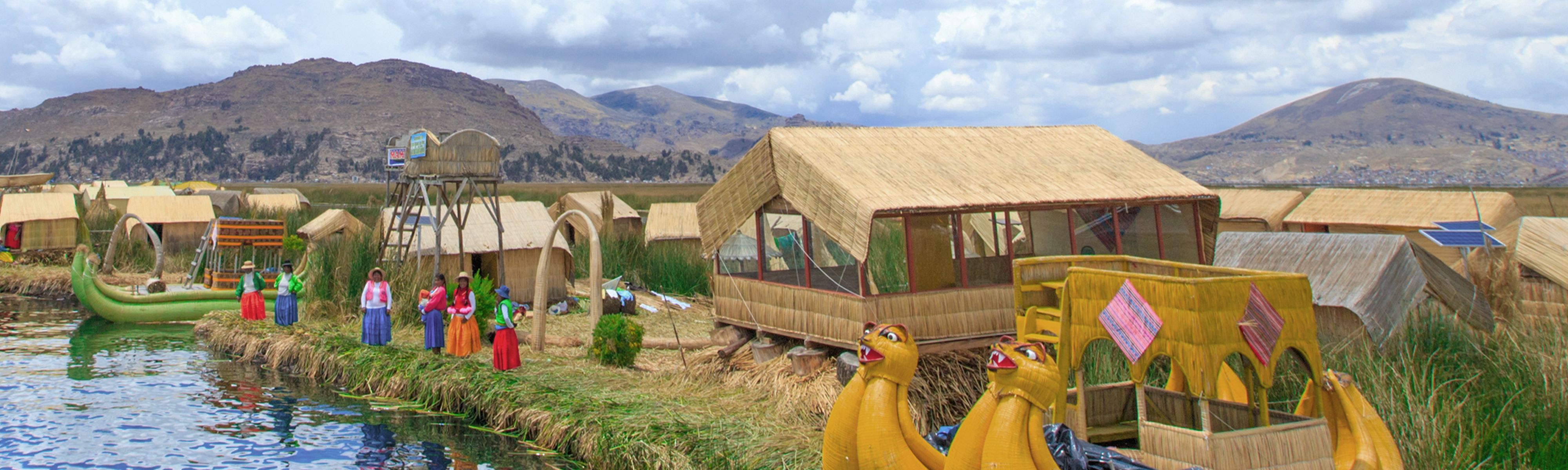 Peruvian people in bright colored skirts standing along lake Titicaca in Peru