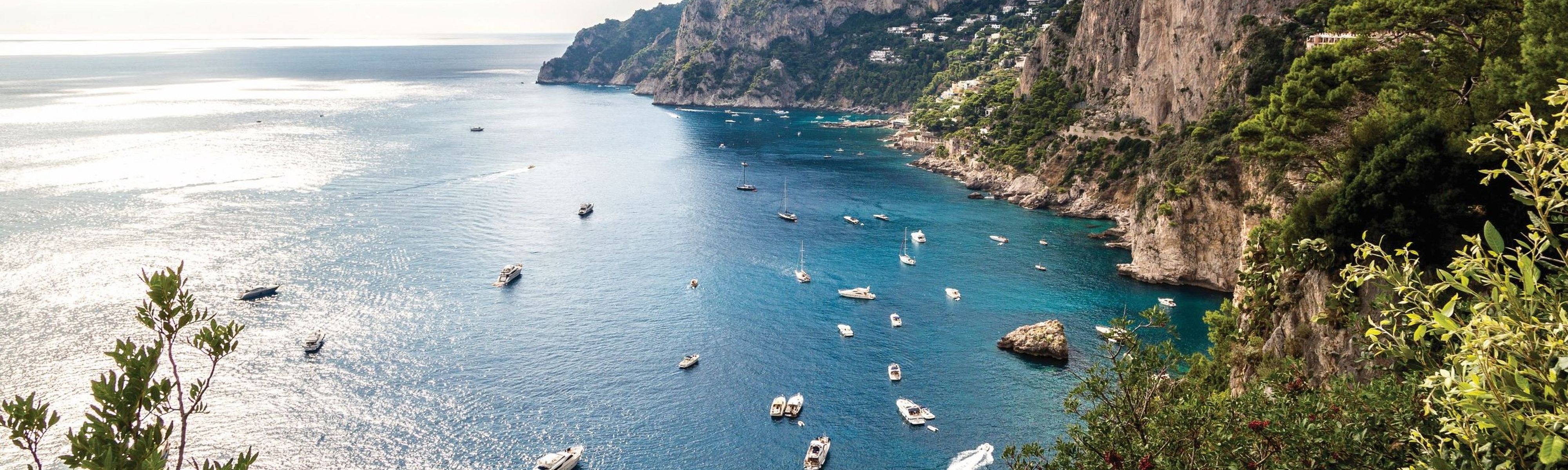 boats riding by coastline of island of capri in italy