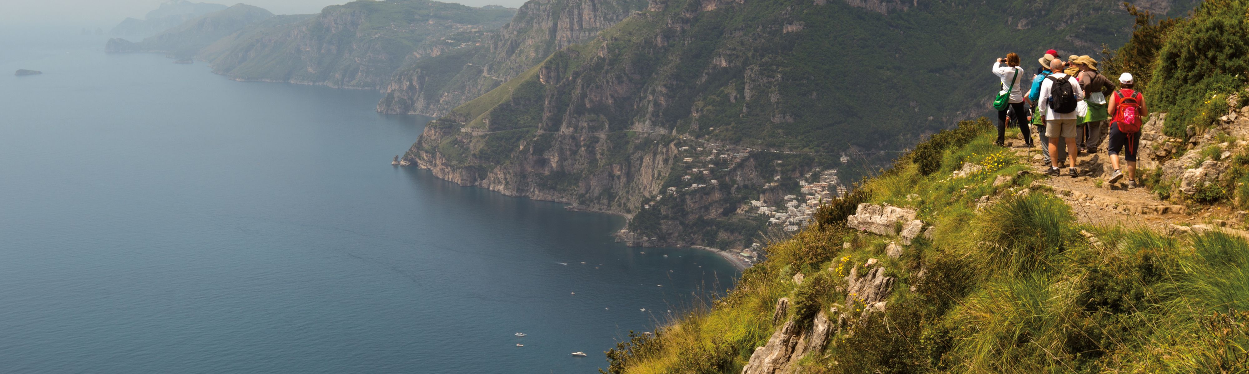 group of travelers walking along trail in the amalfi coast in italy